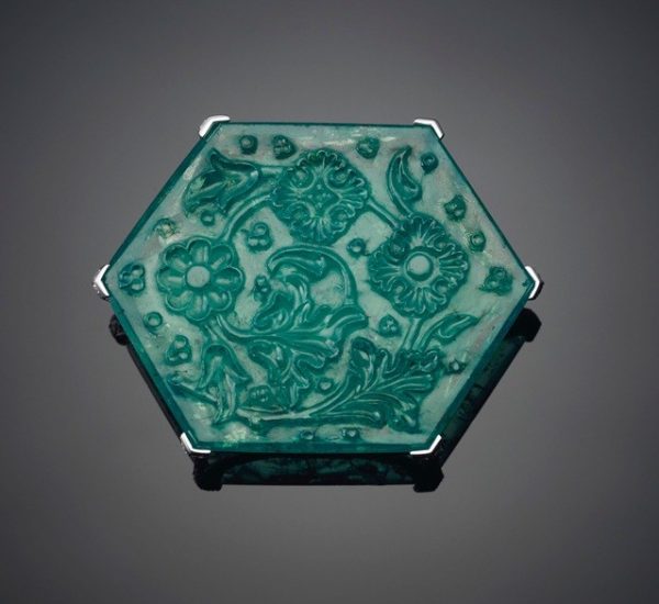 泰姬陵祖母绿，卡地亚。重达141.13克拉的六角形雕刻片状祖母绿、圆形切割钻石、铂金和18K白金（法国标记）。2⅛英寸，2012年。卡地亚签名，编号：TI9645，上面雕刻有“Taj Mahal”（泰姬陵）祖母绿字样的卡地亚红色包装盒